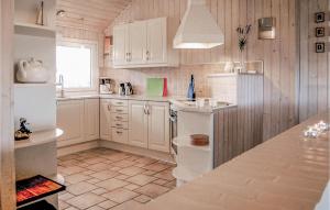 哈夫維格4 Bedroom Gorgeous Home In Hvide Sande的厨房配有白色橱柜和台面
