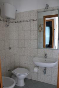 ConocchiaLa collina degli ulivi的一间带卫生间、水槽和镜子的浴室