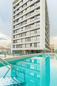 阿雷格里港Apto com incrivel localizacao em Porto Alegre SP的酒店游泳池的背景是一座建筑