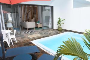 弗利康弗拉克la falaise paradis Mauritius的客厅的游泳池,配有遮阳伞