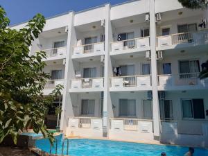 奥兹德雷Palmiye Hotel的公寓大楼前方设有游泳池