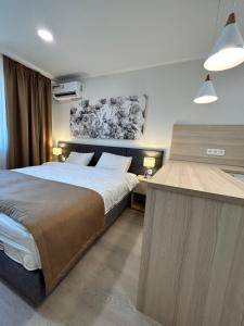 塔尔迪科尔Apart Astana的一间卧室配有一张大床和一张书桌