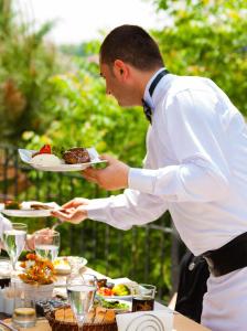 伊斯坦布尔İstanbul Bosphorus Hotel Symbola的把一盘食物放在桌子上的人