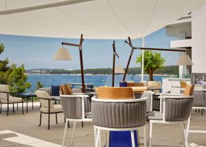 普拉Grand Hotel Brioni Pula, A Radisson Collection Hotel的一个带桌椅的庭院,享有水景