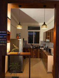 索尼帕特Yb home的厨房配有木制橱柜和不锈钢冰箱。