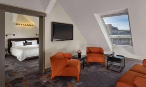 纽伦堡纽伦堡公园广场酒店的酒店客房配有1张床、2把椅子和电视。