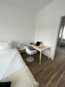 坎佩尔Appartement Design X - Hyper Centre - Parking Privé - Quimper的一间卧室配有一张床和一张带笔记本电脑的书桌
