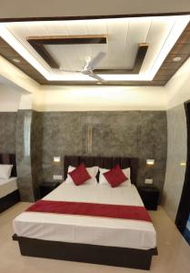 阿格拉Hotel Goyal Palace的一间卧室配有一张带红色枕头的大床