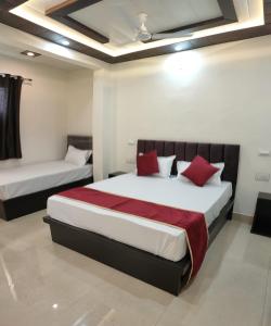 阿格拉Hotel Goyal Palace的一间卧室配有两张带红色枕头的床
