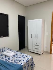 帕尔马斯Flat Dona D - Prox da JK的一间卧室配有床和白色橱柜