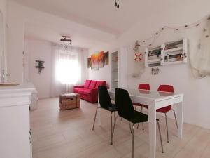 阿奎莱亚Casa Magnolia的客厅配有白色桌子和红色椅子