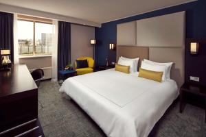 乌得勒支公园广场酒店&度假村的酒店客房配有一张带黄色枕头的大型白色床。