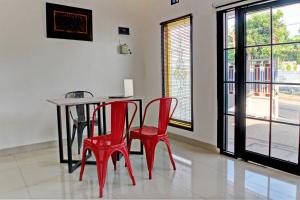 班达楠榜OYO 92945 Guest House Nusa Indah Syariah的一间用餐室,配有红色的椅子和桌子