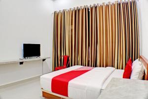 班达楠榜OYO 92945 Guest House Nusa Indah Syariah的一间卧室配有床、电视和窗帘