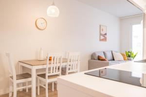 罗瓦涅米Snowflake suites, Pet friendly accommodation的白色的厨房以及带桌椅的客厅。