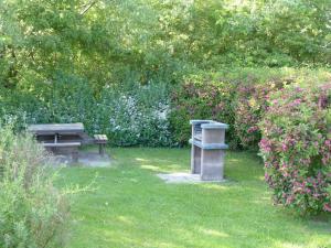 布德明Komfortables Reetdachferienhaus Hasel 1的草上种着长凳和花的公园