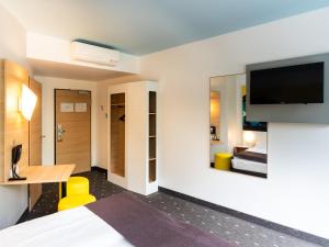 哥廷根哥廷根城B&B酒店的配有一张床和一台平面电视的酒店客房