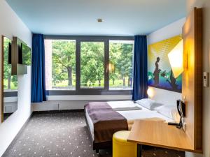 哥廷根哥廷根城B&B酒店的一间卧室配有一张床、一张书桌和一个窗户。