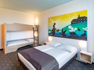 哥廷根哥廷根城B&B酒店的卧室配有一张床,墙上挂着一幅大画