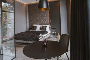 绿山城Apartamenty Kopernika 7的酒店客房配有一张床和一张桌子,桌子上装有四面 ⁇ 