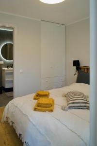 ĶesterciemsSeaside apartment Albatross, 16的一张白色的床,上面有两条毛巾
