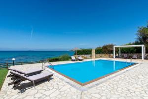 斯达林Beachfront Villa Victoras - With private beach的一个带2把躺椅的游泳池和海洋