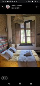 查斯科穆斯Hostería Casa de Campo的一间卧室设有两张床和两个窗户。