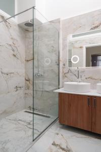 雅典The Aeolian的一间带玻璃淋浴和水槽的浴室