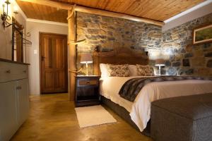 WakkerstroomWetlands Country House & Sheds的一间卧室设有石墙和床