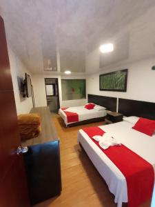 里奥内格罗FINCA HOTEL SANTO TOMAS REAL的一间酒店客房,设有两张床和电视
