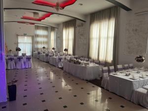普洛耶什蒂Casa Ardeleană的宴会厅配有白色的桌子和白色的椅子