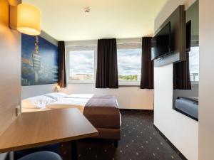 斯图加特B&B Hotel Stuttgart-Airport/Messe的酒店客房配有一张床铺和一张桌子。