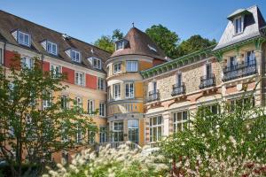 Évaux-les-BainsLe Grand Hôtel, The Originals Relais的一系列的建筑,上面有阳台