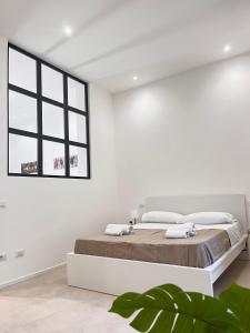 巴勒莫Valguarnera Studio Apartments的白色的卧室设有一张大床和一个窗户