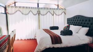 普诺Uros Utasa Lodge的一间卧室设有一张大床和大窗户