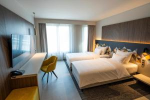 卢布尔雅那奥地利卢布尔雅那潮流酒店的酒店客房设有两张床和一台平面电视。
