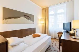 维也纳Hotel Rathauspark Wien, a member of Radisson Individuals的酒店客房配有一张床、一张书桌和一台电视。