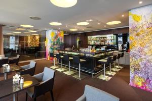 维也纳欧洲维也纳奥地利流行酒店的餐厅设有酒吧和桌椅