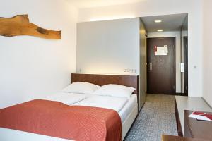 维也纳欧洲维也纳奥地利流行酒店的一间卧室配有一张带红色毯子的床