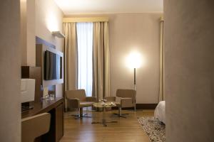 莱切Risorgimento Resort的酒店客房带一张床、一张桌子和椅子
