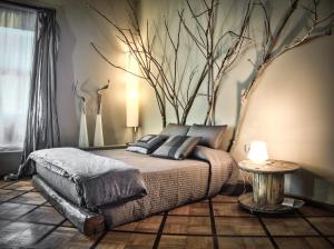 米兰米兰中心床+艺术旅馆的卧室配有一张床铺,墙上挂着一棵树