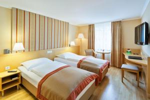 维也纳维也纳阿纳纳斯奥地利时尚酒店的酒店客房配有两张床和一张书桌
