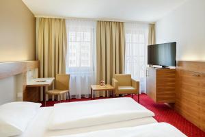 维也纳奥地利阿纳托尔维也纳时尚酒店的配有一张床和一台平面电视的酒店客房