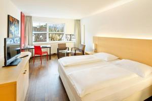 因斯布鲁克议会因斯布鲁克奥地利流行度假酒店的酒店客房配有一张床、一张书桌和一间厨房。