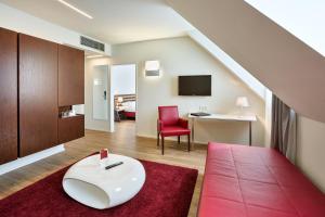 维也纳维也纳奔姆泰丽莎奥地利流行酒店的客厅配有红色椅子和桌子