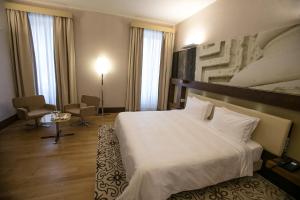 莱切Risorgimento Resort的酒店客房,配有白色的床和椅子