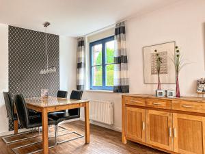 博尔滕哈根Papillon Wohnung 04-1的一间带桌椅和窗户的用餐室