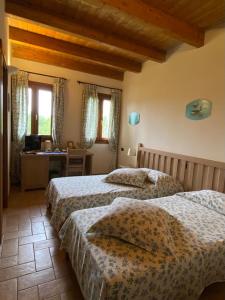 La Casetta di Alessia - Agriturismo con camere的一间卧室设有两张床、一张桌子和窗户。