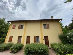 La Casetta di Alessia - Agriturismo con camere的黄色的房子,设有窗户和屋顶