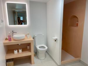 邦多勒La naronne的一间带卫生间、水槽和镜子的浴室